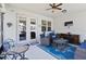 Comfortable covered patio featuring two armchairs, a coffee table, and a TV at 12335 Sumter Dr, Orlando, FL 32824