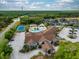 Aerial view featuring the pool, tennis courts, clubhouse and surrounding neighborhood at 135 Orchid Dr, Davenport, FL 33897