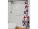 A recently updated shower with tiled wall, modern fixture and a colorful shower curtain at 135 Orchid Dr, Davenport, FL 33897