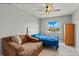 Bright bedroom with a ceiling fan, a window with a view, and a loveseat at 135 Orchid Dr, Davenport, FL 33897
