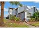 Stylish blue townhome featuring mature landscaping and a cozy front entrance at 135 Orchid Dr, Davenport, FL 33897