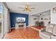 Open-concept living room with wood floors, ceiling fan, and a seamless transition to the dining area at 135 Orchid Dr, Davenport, FL 33897