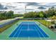 Overhead shot of the community's pristine blue and green tennis court, surrounded by lush greenery at 135 Orchid Dr, Davenport, FL 33897