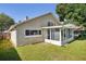 Exterior view of home, showing sunroom addition and grassy backyard at 143 Abbey Hollow Dr, Apopka, FL 32712