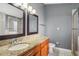 Bathroom with double sinks, granite countertop, and a tiled shower with glass door at 143 Abbey Hollow Dr, Apopka, FL 32712