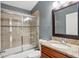 Bathroom with granite-topped vanity and tiled shower and tub with glass doors at 143 Abbey Hollow Dr, Apopka, FL 32712