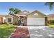 Charming single-Gathering home featuring a two-car garage, brick accents, and a well-maintained lawn at 143 Abbey Hollow Dr, Apopka, FL 32712