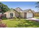 Beautifully landscaped home exterior with brick accents and two-car garage at 143 Abbey Hollow Dr, Apopka, FL 32712