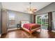 Cozy bedroom with hardwood floors, a ceiling fan, and sliding glass doors to the backyard at 143 Abbey Hollow Dr, Apopka, FL 32712