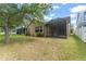 Expansive backyard featuring a screened-in lanai, lush greenery, and mature trees for shade at 14537 Cheever St, Orlando, FL 32828