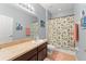 Bathroom featuring neutral walls, shower with a colorful curtain, and vanity with a wide mirror at 14537 Cheever St, Orlando, FL 32828