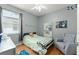 Cozy bedroom featuring a large window, white bookshelf and a comfortable armchair at 14537 Cheever St, Orlando, FL 32828