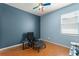 Comfortable bedroom featuring blue walls, wood floors, and a cozy armchair at 14537 Cheever St, Orlando, FL 32828