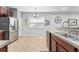 Bright kitchen with stainless steel refrigerator, granite countertops, tile floor, and modern finishes at 14537 Cheever St, Orlando, FL 32828