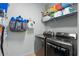 Functional laundry room with washer, dryer, and shelving for storage at 14537 Cheever St, Orlando, FL 32828