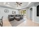 Living room with comfortable gray sectional sofa and view to lanai with ceiling fan at 14537 Cheever St, Orlando, FL 32828