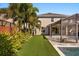 Beautiful backyard with well-manicured artificial lawn, tropical palms, and a screened lanai for outdoor enjoyment at 14742 Bahama Swallow Blvd, Winter Garden, FL 34787