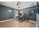Bedroom featuring hardwood floors, fan, and a workspace with two chairs and two monitors at 14742 Bahama Swallow Blvd, Winter Garden, FL 34787