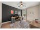 Bedroom featuring a desk, hardwood floors, black accent wall and bright light at 14742 Bahama Swallow Blvd, Winter Garden, FL 34787