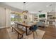 Dining area showcases a rustic wood table, modern lighting, and seamless access to both living room and outdoor pool at 14742 Bahama Swallow Blvd, Winter Garden, FL 34787