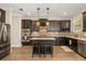 Modern kitchen features an island, granite countertops, stainless steel appliances, and dark wood cabinetry at 14742 Bahama Swallow Blvd, Winter Garden, FL 34787