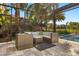 Relaxing screened-in lanai with wicker seating, lush landscaping, and a view of the sparkling pool at 14742 Bahama Swallow Blvd, Winter Garden, FL 34787