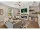 Cozy living room features an electric fireplace with stone accents, built-in shelving, and bright natural light at 14742 Bahama Swallow Blvd, Winter Garden, FL 34787