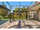 Inviting screened-in patio with pavers, lush landscaping, and a view of the backyard and tropical palm trees at 14742 Bahama Swallow Blvd, Winter Garden, FL 34787