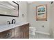 Charming bathroom featuring dark wood vanity, marble countertop, and framed mirror, exuding classic style at 1512 Adriatic Dr, Ocoee, FL 34761