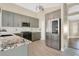 Modern kitchen featuring gray cabinets, stainless steel appliances, granite countertops, and tile backsplash at 1512 Adriatic Dr, Ocoee, FL 34761