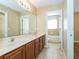 Bright bathroom with a double sink vanity, tile flooring, and a view of the bathtub at 173 Donner Dr, Winter Garden, FL 34787