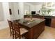 Kitchen island with granite countertop, bar seating, and ample storage in a naturally lit open space at 1937 Crystal Downs Ct, Oviedo, FL 32765