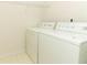 Bright laundry room features updated washer and dryer with convenient wire shelving at 1937 Crystal Downs Ct, Oviedo, FL 32765