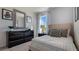 Modern bedroom featuring a full bed, black dresser, a patterned mirror, and a window with natural light at 198 Amberwood Way, Umatilla, FL 32784