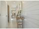Bright hallway with white shiplap walls, a decorative console table, and tile flooring at 198 Amberwood Way, Umatilla, FL 32784