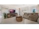 Cozy living room featuring a neutral-toned sofa, stylish coffee tables, and a large television at 198 Amberwood Way, Umatilla, FL 32784