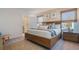 Spacious main bedroom featuring a king bed, ensuite bathroom, wood accents, and window at 198 Amberwood Way, Umatilla, FL 32784
