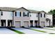 Attractive townhome exteriors with gray paint, single-car garage, black shutters, and manicured landscaping at 2052 Monteverde Ave, Davenport, FL 33837