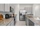 Modern kitchen with stainless appliances, granite counters, and gray cabinets at 2052 Monteverde Ave, Davenport, FL 33837