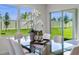 Dining area showcasing a glass-top table, stylish seating, and a view of the outdoors through a bright, large window at 207 Taylor Groves Dr, Lake Wales, FL 33898