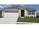 Charming one-story home with a well-manicured lawn, a two-car garage, and a welcoming front entrance at 207 Taylor Groves Dr, Lake Wales, FL 33898