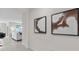 Well-lit hallway featuring neutral decor, modern artwork, and a glimpse into the living area with comfortable seating at 207 Taylor Groves Dr, Lake Wales, FL 33898