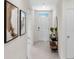 Hallway with neutral walls and tile flooring, accented by modern artwork and a console table at 207 Taylor Groves Dr, Lake Wales, FL 33898