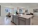 Open concept kitchen featuring an island with a sink, modern cabinetry, and views into the dining and living areas at 207 Taylor Groves Dr, Lake Wales, FL 33898