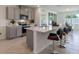 Stylish kitchen featuring grey cabinetry, stainless steel appliances, a spacious island with bar seating, and an open layout at 207 Taylor Groves Dr, Lake Wales, FL 33898