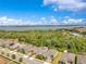 Beautiful aerial view of homes near a tranquil lake and lush green trees under a blue sky with white clouds at 2127 Bay Line Rd, Oakland, FL 34787