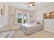 Cozy bedroom with a queen-sized bed, ceiling fan, and view to lush trees through two windows at 2127 Bay Line Rd, Oakland, FL 34787