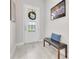 Bright foyer with a decorative front door, bench, and light wood-look tile flooring at 2127 Bay Line Rd, Oakland, FL 34787