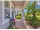 Inviting covered front porch with comfortable bench seating and verdant tropical landscaping at 2127 Bay Line Rd, Oakland, FL 34787