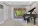 Music room features a grand piano and sliding doors to an outdoor area at 2127 Bay Line Rd, Oakland, FL 34787